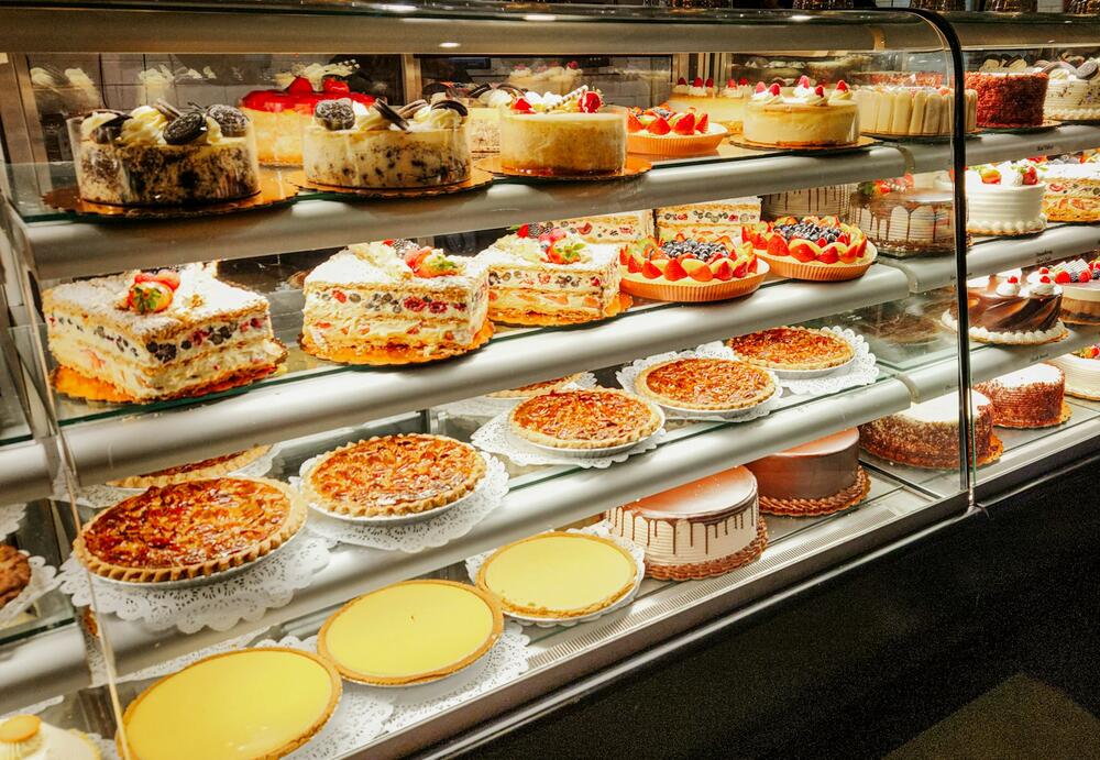 A display case of layer cakes, fruit cakes and pies