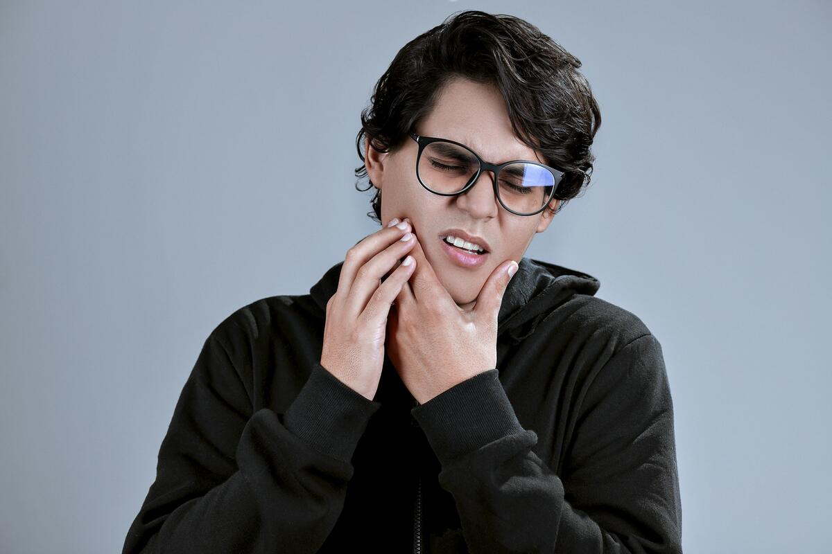 A young man holding his jaw with a toothache