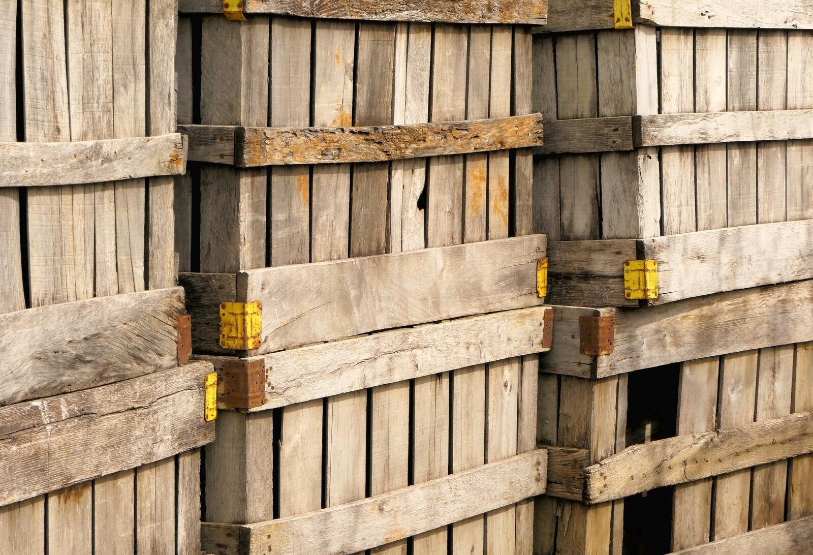 Stacked wooden storage crates with yellow corner brackets