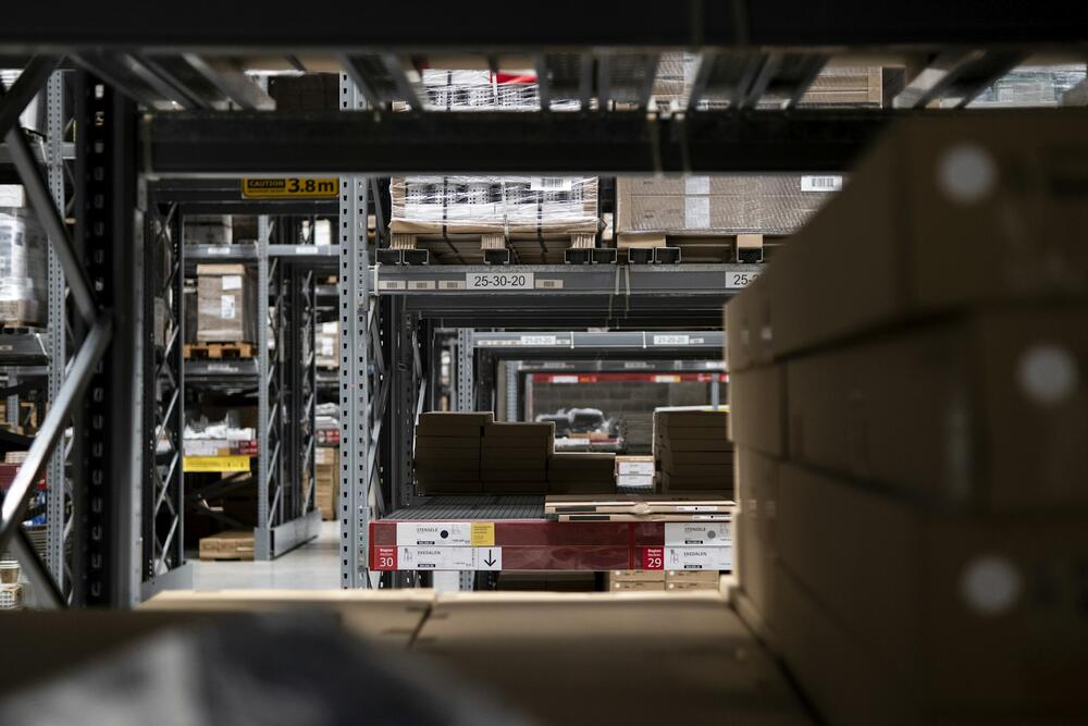 A warehouse aisle of pallet racking stacked with boxes